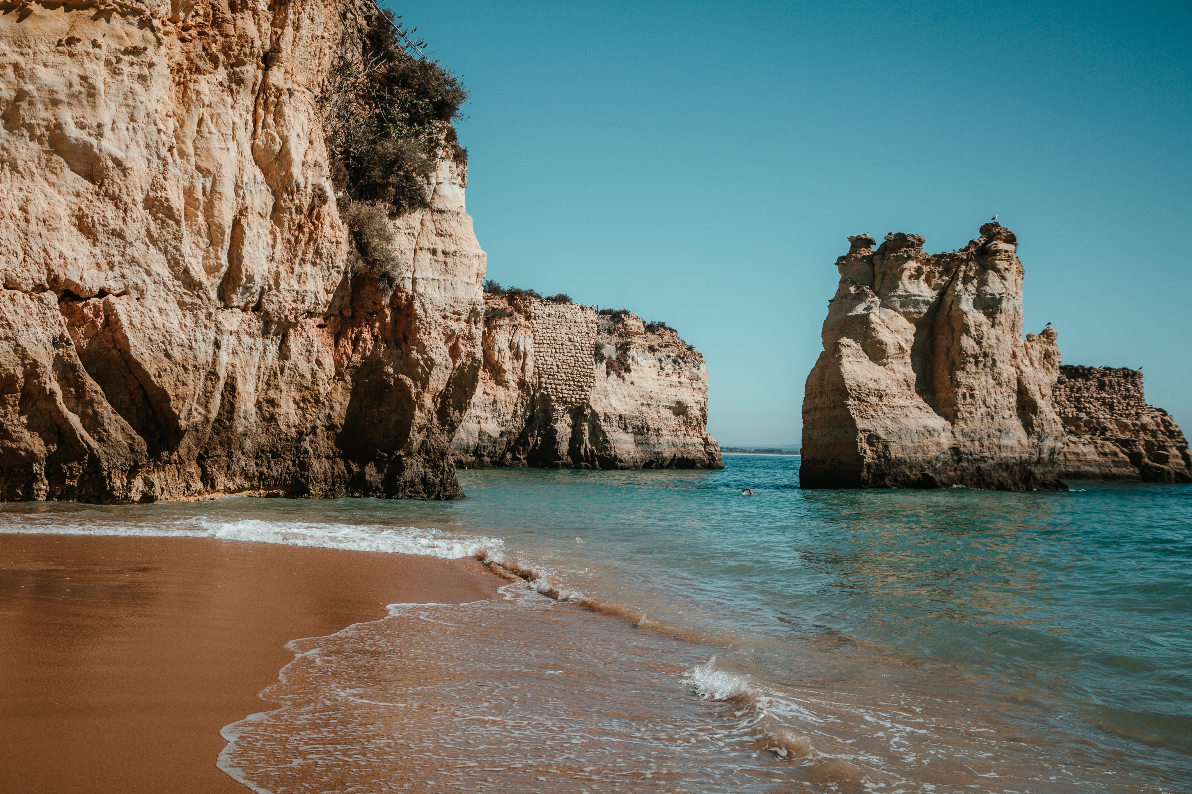 sandy-beach-by-rocky-cliffs.jpg